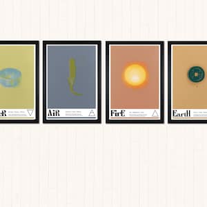 May include: Four framed art prints with black borders. Each print features a different element: Water, Air, Fire, and Earth. The Water print shows a blue bowl, Air has a yellow shape, Fire displays a sun, and Earth shows a coin. Each print has text.
