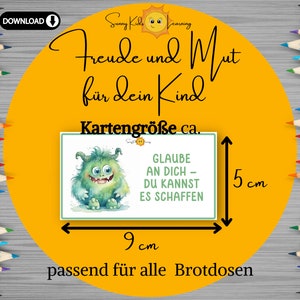 May include: A yellow circle with the text "Freude und Mut f&uuml;r dein Kind" and a cartoon sun. The text "Kartengr&ouml;&szlig;e ca." is below the sun. A white card with a green monster and the text "GLAUBE AN DICH - DU KANNST ES SCHAFFEN" is shown with measurements of 9 cm by 5 cm. The text "passend f&uuml;r alle Brotdosen" is below the card.