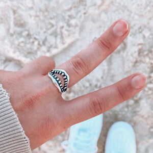 Shark Jaw Ring on hand giving the peace sign