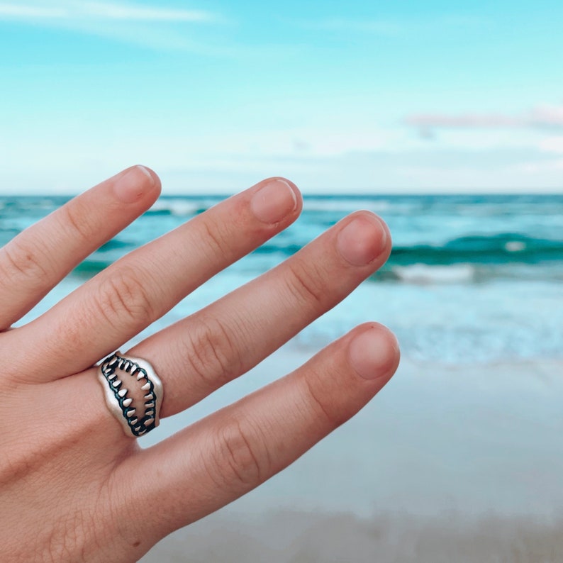 Shark Jaw Ring on hand in front of the ocean