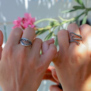 Shark Jaw Ring on a hand holding a hand with an octopus ring