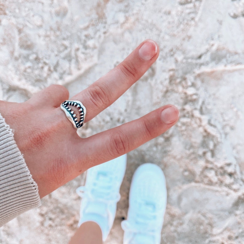 Shark Jaw Ring on hand giving the peace sign