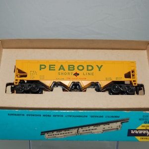 May include: A yellow Peabody Short Line model train car in its original box. The car has black wheels and the text "PEABODY SHORT LINE" in green. The box is blue and has the Athearn Trains logo.