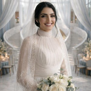 May include: A bride in a white wedding dress with a high neckline and long sleeves, holding a bouquet of white roses and greenery. She wears a veil with pearl detailing. The background features a grand hall with a staircase and floral arrangements.