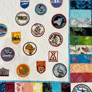 以下が含まれることがあります： 様々な刺繍パッチが施された白いキルト。パッチには、チャールストン（サウスカロライナ州）、キーウェスト（フロリダ州）、ワールドトレードセンターなど、さまざまな場所が描かれています。また、ウォルトディズニーワールドやリングリングサーカス博物館のパッチもあります。