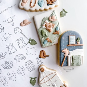 Op de afbeelding: Een set van zes gedecoreerde suikerkoekjes met een western thema. De koekjes hebben verschillende ontwerpen, waaronder een cowboylaars, een cactus, een hoefijzer, een ster, een bandana en een babymobiel. De koekjes zijn versierd met royal icing en zijn perfect voor een babyshower of verjaardag.