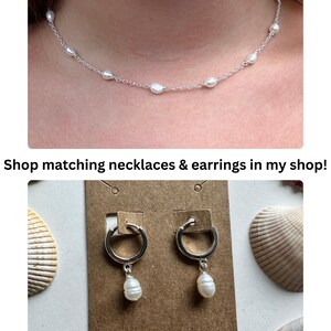 Puede incluir: Un collar de cadena plateada con peque&ntilde;as perlas blancas de forma irregular espaciadas uniformemente. Un par de pendientes de aro plateados con dijes de perlas blancas colgantes sujetos a una tarjeta marr&oacute;n con OMara Jewelry.