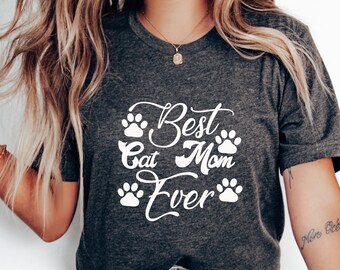 May include: A dark gray t-shirt with white text that reads "Best Cat Mom Ever" with paw prints surrounding the text.