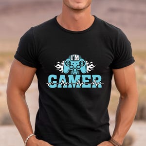 May include: Black t-shirt with a blue graphic of a video game controller and the text "I'm a Gamer" with a blue heartbeat line.