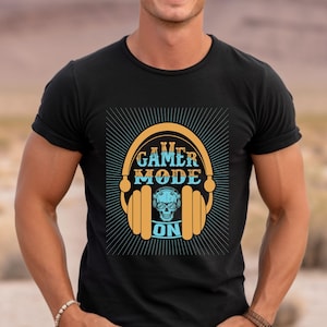 May include: Black t-shirt with a graphic of headphones with the text "Gamer Mode On" in orange and blue.