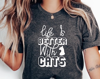 May include: A dark gray t-shirt with the text "life is better with cats" in white. A white silhouette of a cat's head is included in the text.