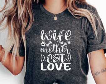 May include: A gray t-shirt with the text "wife mother (cat) love" printed in white. The text is in a cursive font and includes paw prints and bone icons.