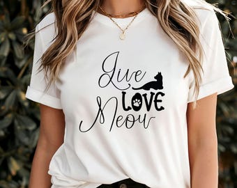 Peut inclure: T-shirt blanc à manches retroussées avec l'inscription "Live Love Meow" en écriture cursive. Un chat noir et une empreinte de patte sont intégrés au design. C'est un vêtement décontracté pour tous les jours.