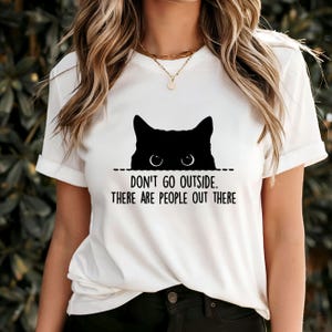 Ne sortez pas, il y a des gens là-bas, t-shirt graphique cachant un chat noir drôle, chemise à humour introverti, cadeau original pour amoureux des chats