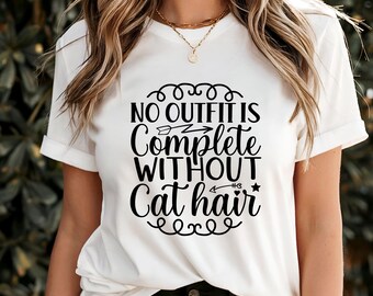 Pode incluir: Camiseta branca com o texto preto "NO OUTFIT IS COMPLETE WITHOUT Cat hair" em uma fonte lúdica. A camiseta tem mangas curtas e gola redonda. O texto está centralizado na frente.