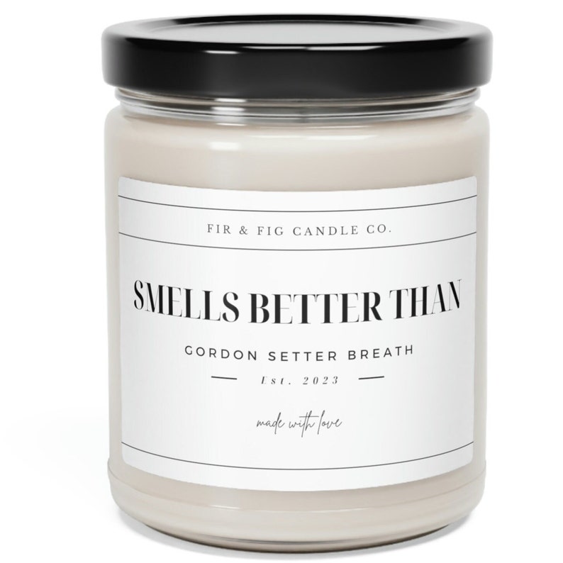 以下が含まれることがあります： 黒い蓋が付いた白いキャンドルジャー。ラベルには「FIR & FIG CANDLE CO. SMELLS BETTER THAN GORDON SETTER BREATH Est. 2023 made with love」と書いてあります