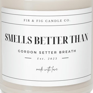 以下が含まれることがあります： 「FIR & FIG CANDLE CO. SMELLS BETTER THAN GORDON SETTER BREATH Est. 2023 made with love」と黒色のラベルが貼られた白いキャンドルジャー