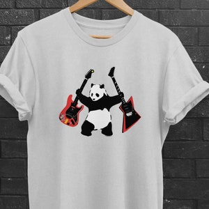 May include: A white t-shirt with a black and white panda bear holding two electric guitars. One guitar is red and the other is black.