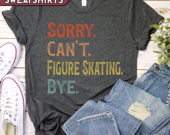 May include: Dark gray t-shirt with the text "SORRY. CAN'T. FIGURE SKATING. BYE." in orange, tan, yellow, and teal. The shirt is paired with blue jeans and white sneakers. The top left corner of the image has the text "T-SHIRTS & SWEATSHIRTS."