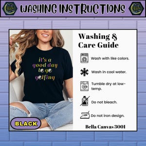May include: Black t-shirt with the text "it's a good day to go golfing" in purple and yellow. The image also includes a washing and care guide with instructions to wash with like colors, wash in cool water, tumble dry at low-temp, do not bleach, and do not iron design.