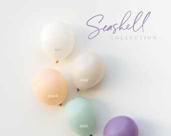 May include: Six pastel-colored latex balloons with the words "lace", "sand", "peach", "mint", "purple", and "DREAM + air" written on them. The balloons are arranged in a circle on a white background. The text "Seashell Collection" is written in purple script at the top of the image.