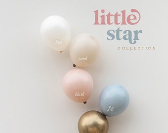 May include: A set of six latex balloons in various pastel colours, including lace, sand, blush, fog, and gold. The balloons are arranged in a semi-circle and feature the text "little star collection" above them.