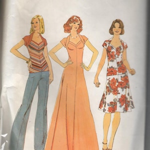 May include: Simplicity sewing pattern 7267 featuring three different dress designs. The illustrations show a long peach dress, a floral print dress, and a top with pants. The pattern is sized for stretch knits.