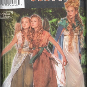 May include: Simplicity Costumes pattern featuring three women in flowing, fantasy-themed gowns. The costumes include a white dress with gold accents, a brown dress with a green sash, and a dress with a white overlay. The pattern includes sizes 6, 8, 10, and 12.