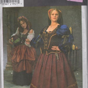 May include: A Simplicity Costumes sewing pattern envelope, number 3249, size GG 26W-32W. The front displays two historical-style outfits: one with a dark bodice, blue sleeves, and a long maroon skirt, and another with a white blouse and brown skirt.
