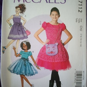 May include: A sewing pattern for a girl's dress with a pink, purple, and blue dress. The pattern includes instructions for making a dress with a tulle skirt and a matching purse. The pattern is for sizes 7-8, 10-12, and 14.