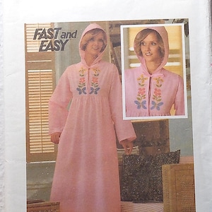 May include: A vintage Butterick sewing pattern, size small, featuring a pink hooded robe with floral embroidery. The pattern includes the text "FAST and EASY" and the Butterick logo.
