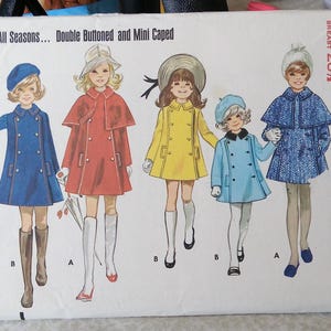 May include: Vintage Butterick sewing pattern featuring illustrations of children's coats. The pattern includes double-breasted and mini-caped coat designs in various colors, with sizes ranging from 4 to 12. The text on the pattern reads "Coat for All Seasons... Double Buttoned and Mini Caped."