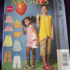May include: A sewing pattern for a girl's outfit, featuring a yellow top with a ruffled hem and a pair of patterned pants. The pattern is labeled "M7149" and "CHJ (7-8-10-12-14)".