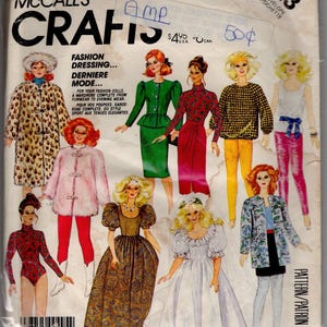 May include: A McCalls Crafts sewing pattern envelope numbered 823, featuring illustrations of fashion dolls wearing various outfits including a leopard print coat, a green suit, a pink fur jacket, a wedding dress, and casual separates with text.