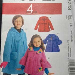 May include: McCall's sewing pattern for children's coats, sizes 7-8, 10-12, and 14. The pattern includes four different styles: a red coat with a hood, a blue coat with a hood, a pink coat with a ruffled collar, and a blue coat with a ruffled collar. The pattern is labeled "Great Looks, One Easy Pattern".