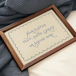 Op de afbeelding: Een rechthoekige fotolijst met een metallic bronzen afwerking en een crèmekleurige inzet. De inzet is voorzien van een blauwe geschulpte rand en de blauwe handgeschreven tekst: Your custom text, quote, lyrics or saying here.