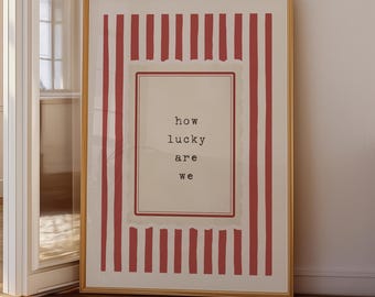 Póster vintage con la frase "How Lucky Are We" y una máquina de escribir con rayas rojas (descarga digital).