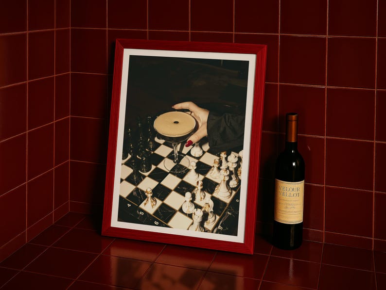 Moody photograph of a hand with red nails holding a martini over a chessboard, dramatic bar and game night themed wall art, printable decor