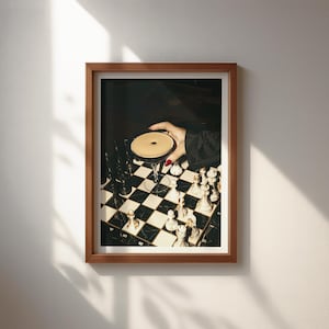 Moody photograph of a hand with red nails holding a martini over a chessboard, dramatic bar and game night themed wall art, printable decor