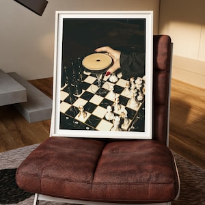 Moody photograph of a hand with red nails holding a martini over a chessboard, dramatic bar and game night themed wall art, printable decor
