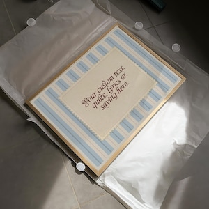 Framed custom quote printable with vintage cream parchment and pale blue vertical stripes. Editable wall art for personalized messages, lyrics, or names – perfect for baby gifts, coastal decor, or soft romantic spaces.