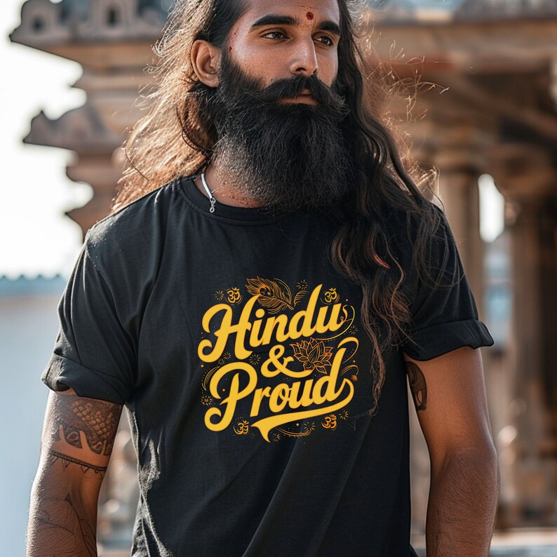 Puede incluir: Una camiseta negra con un gr&aacute;fico dorado que dice "Hindu & Proud" con una flor de loto y s&iacute;mbolos Om.