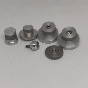 May include: A set of six silver metal parts, including a screw, a small round knob, and four round discs with a raised centre.