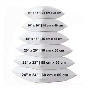 May include: Six white pillows of different sizes are stacked. The pillows are labelled with their dimensions in inches and centimetres, ranging from 35 cm x 35 cm to 60 cm x 60 cm.