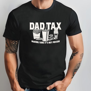K&ouml;nnte beinhalten: Schwarzes T-Shirt mit dem wei&szlig;en Text "DAD TAX" &uuml;ber einer Illustration von Pommes Frites, einem Getr&auml;nk, einem Burger und einem Eis. Der Satz "MAKING SURE IT'S NOT POISON" ist darunter gedruckt.