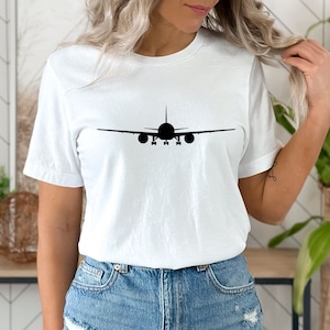 May include: White t-shirt with a black silhouette of an aeroplane on the front.