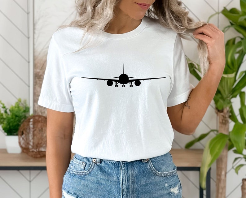 May include: White t-shirt with a black silhouette of an aeroplane on the front.