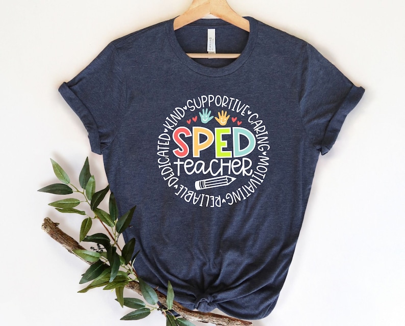 Pode incluir: Uma camiseta azul marinho com um design circular branco que diz "SPED teacher" em letras coloridas. O c&iacute;rculo &eacute; rodeado pelas palavras "dedicado, gentil, solid&aacute;rio, atencioso, motivador, confi&aacute;vel" em branco.