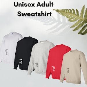 May include: Five unisex adult sweatshirts in different colors: white, black, ash, red, and sand. The sweatshirts are laid out in a row, with the white sweatshirt on the left and the sand sweatshirt on the right.