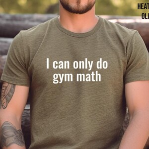 May include: A heather olive t-shirt with the text "I can only do gym math" printed in white.